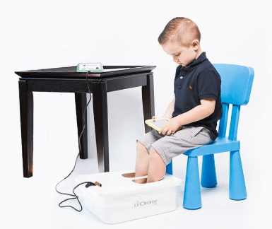 Child using an ionic foot detox bath to support gentle detoxification and overall wellness naturally